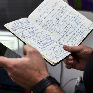 a person holding a book and a cell phone